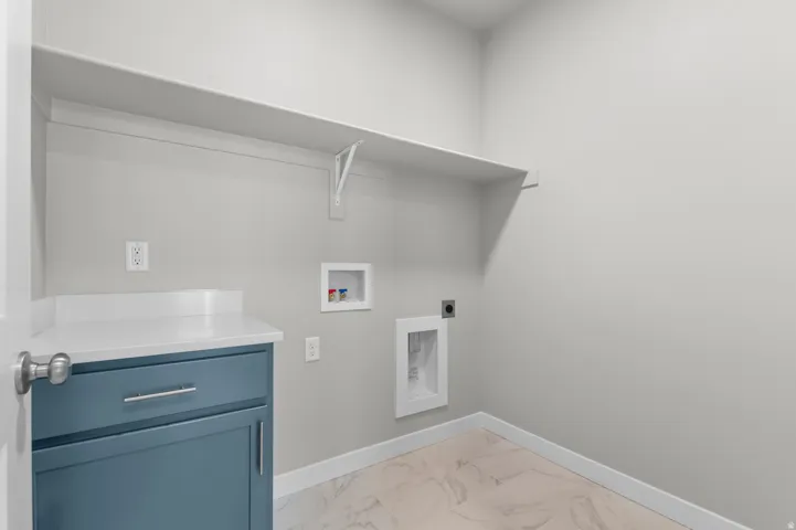 Built-in shelving, blue cabinetry, light-toned countertop, and tile flooring