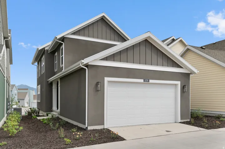 Contemporary exterior with two-story stucco facade, gabled rooflines, and white trim accents