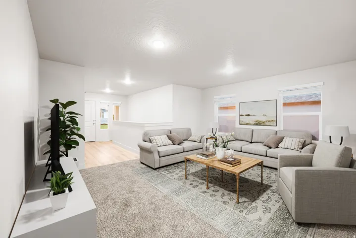 Spacious living area featuring neutral carpeting and light wood-finish flooring