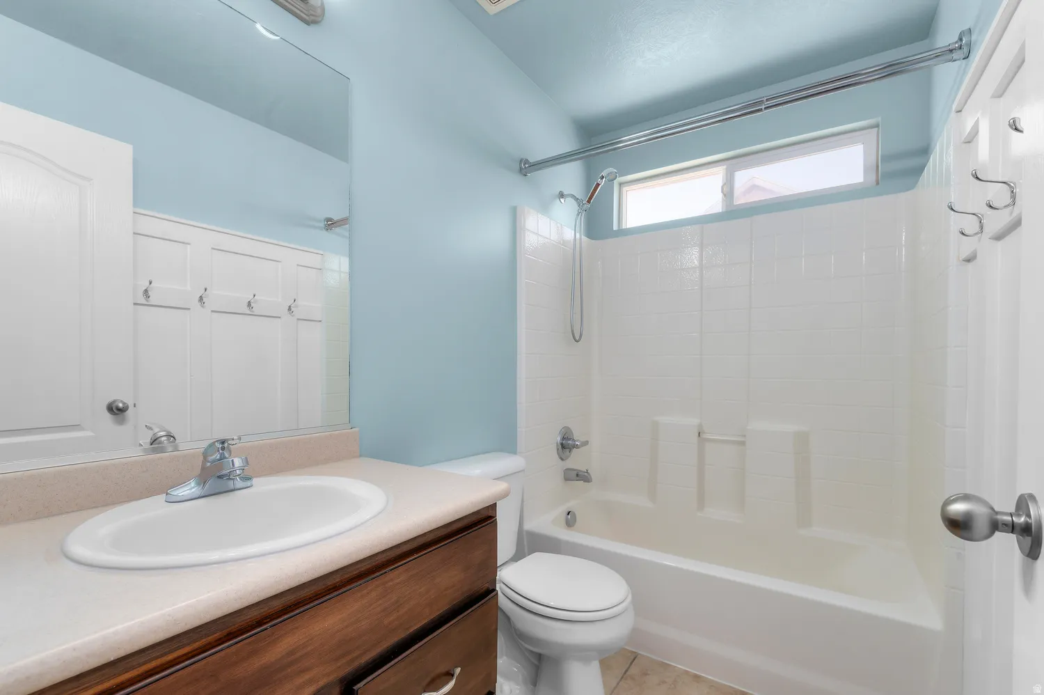 Bathroom featuring a vanity with an integrated sink, a wood-finish cabinet, and a mirror