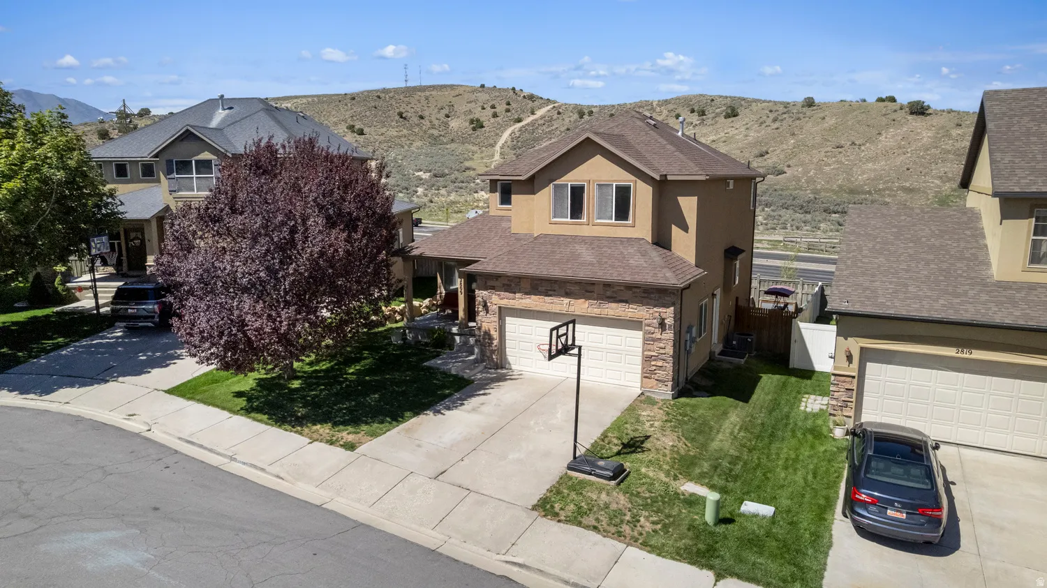 Two-story residence with a two-car garage, stone veneer accents, and a front-facing driveway