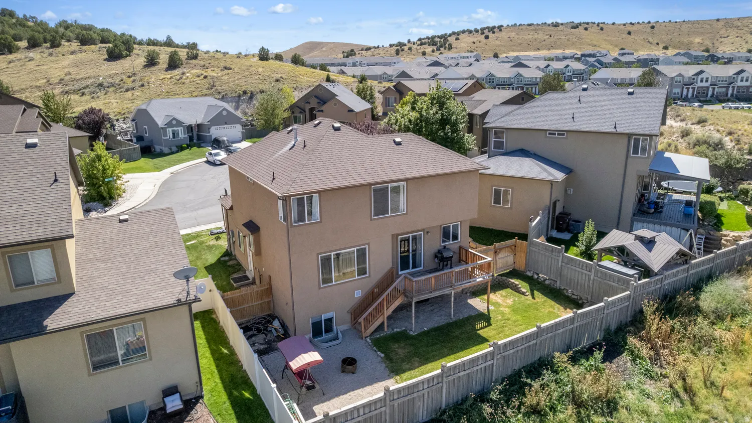 Backyard featuring a wooden deck with stairs, a level lawn area, and a privacy fence