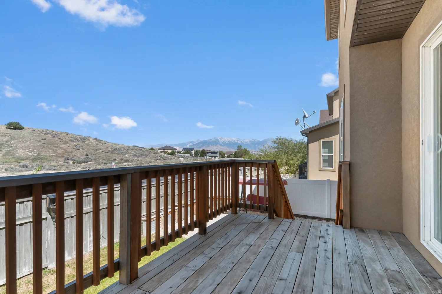 Wood-finish deck with a wood railing and a sliding glass door