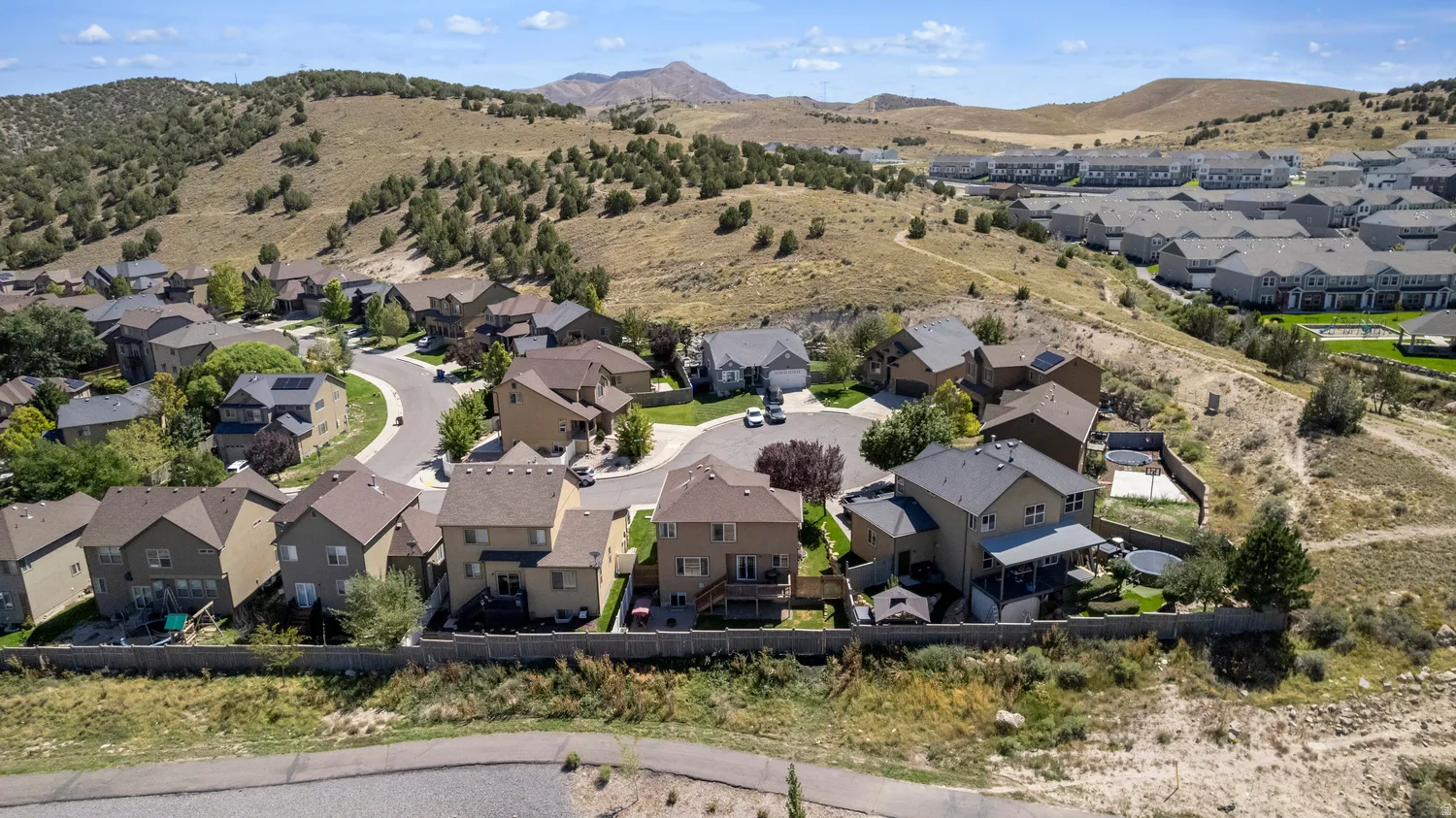Residential development featuring various home styles and surrounding natural terrain