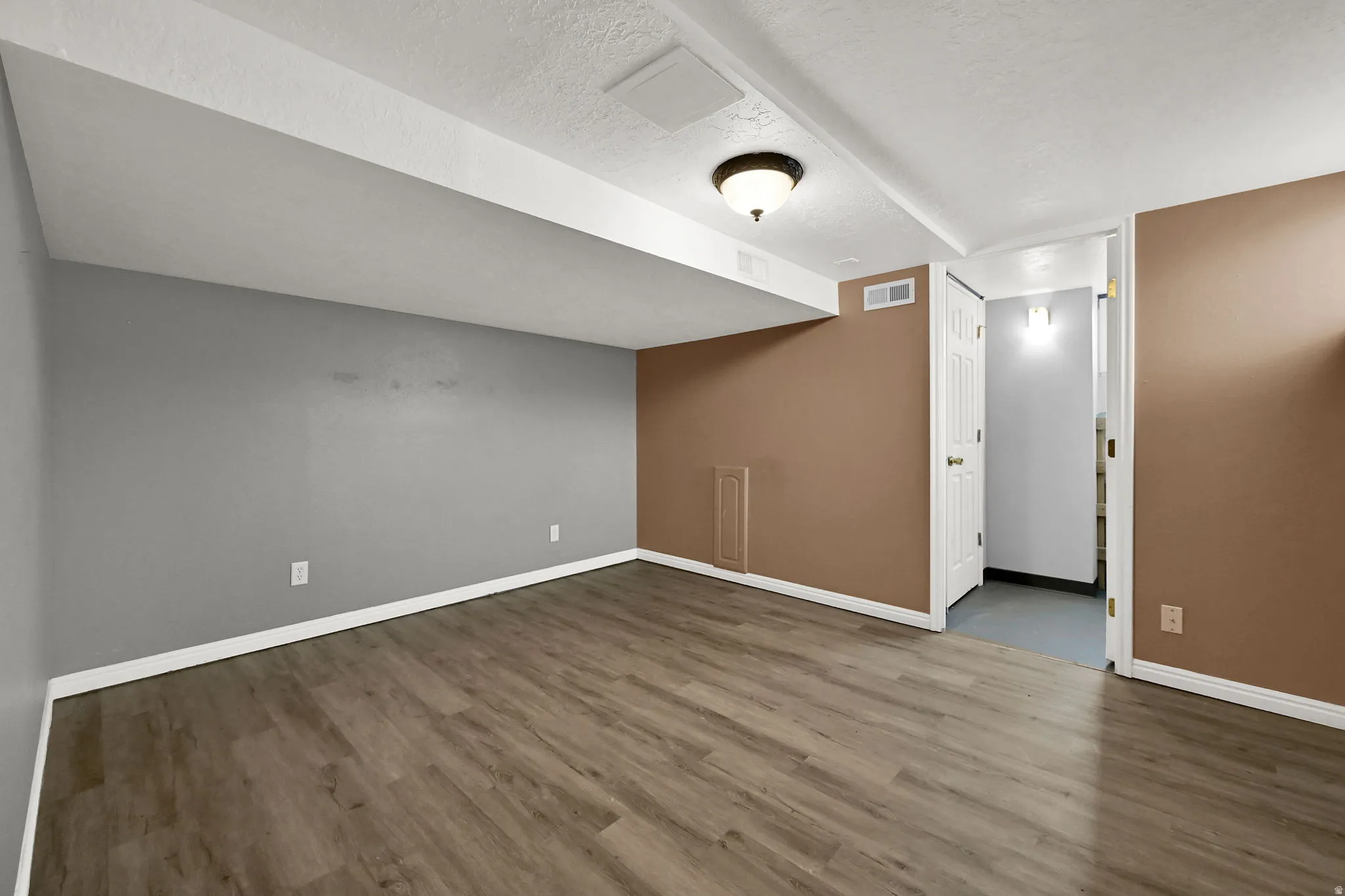 Wood-finish flooring, recessed lighting, and a neutral color palette