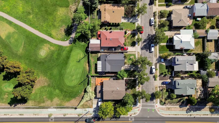 Aerial perspective of a residential neighborhood with a golf course bordering properties