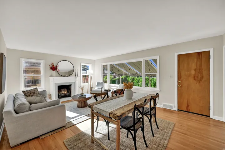 Hardwood flooring, white window trim, white fireplace mantel, gas fireplace insert, wood-finish entry door