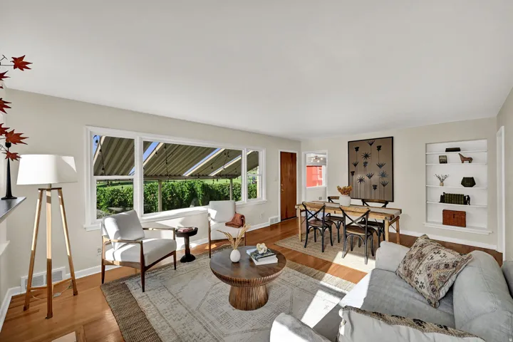 Hardwood flooring, expansive window, built-in shelving, wood door, and recessed dining space