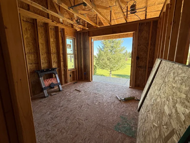 Framed interior space with exposed ceiling joists and wall studs