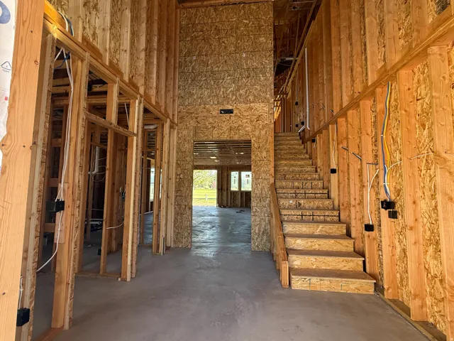 Two-story foyer with a grand staircase and wood framing