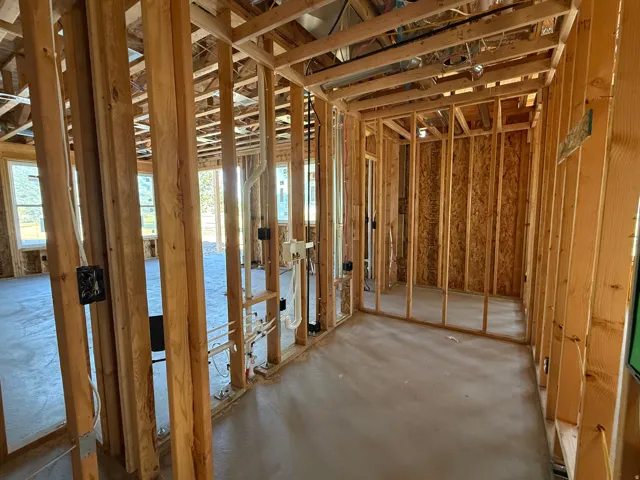 New construction framing with exposed plumbing and electrical rough-ins