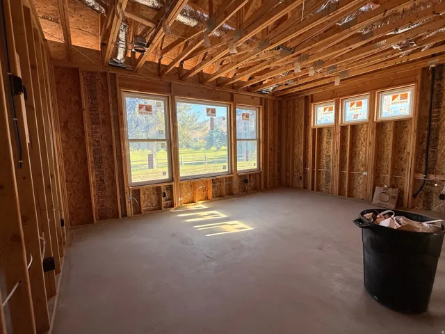 Exposed ceiling joists, multiple windows, and a concrete floor