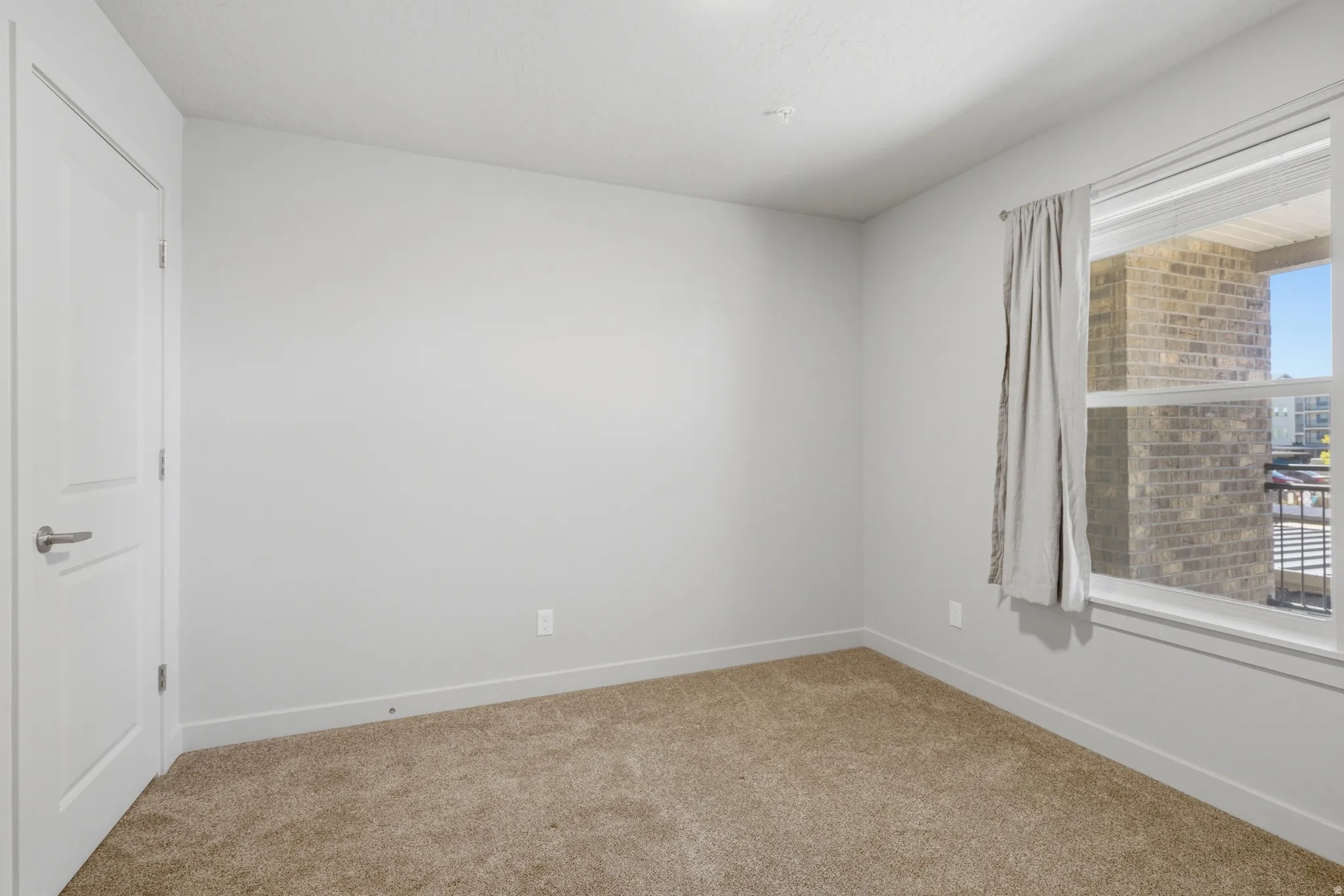 Neutral color palette with broadloom carpeting, white trim, and a white interior door