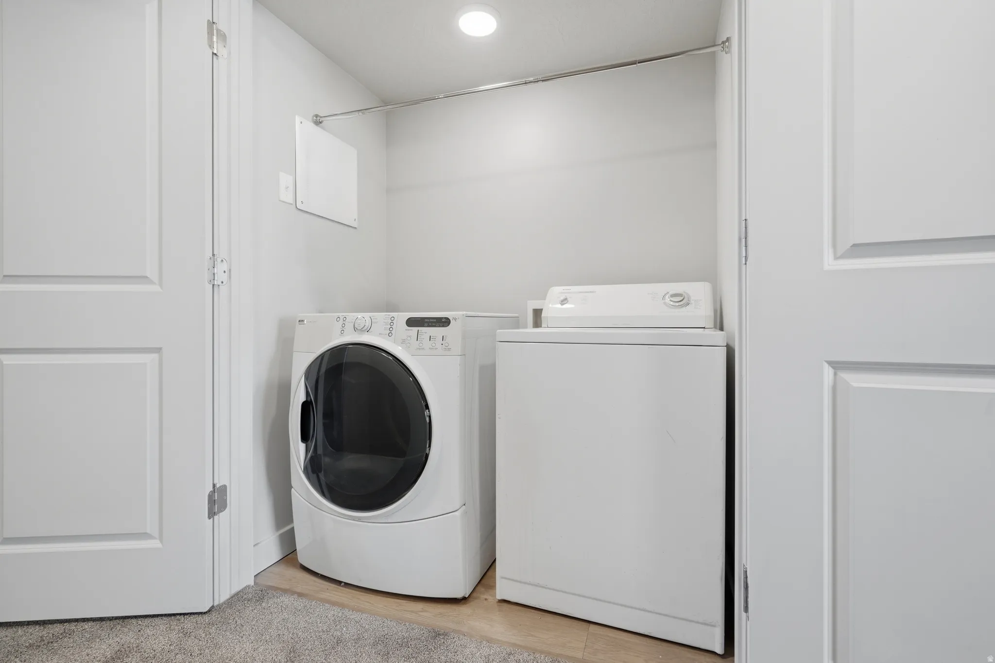 Recessed ceiling light, clothes hanging rod, built-in washer and dryer appliances, panel doors, and neutral wall finish