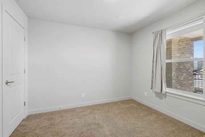 Neutral color palette with broadloom carpeting, white trim, and a white interior door