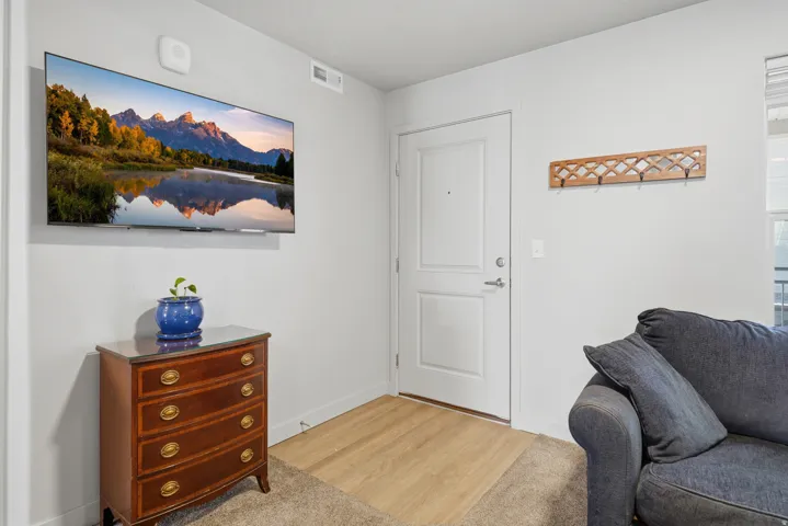 Entryway featuring a white paneled door, wood-finish flooring, and light-colored wall paint