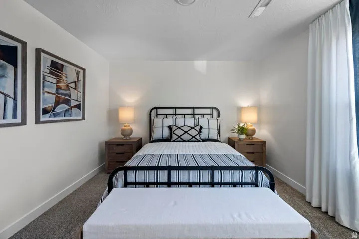 Bedroom featuring carpet flooring, a window with curtains, and a ceiling fan