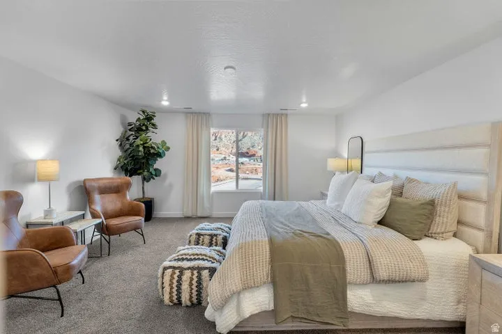Spacious room with plush carpet flooring, recessed lighting, and a large window