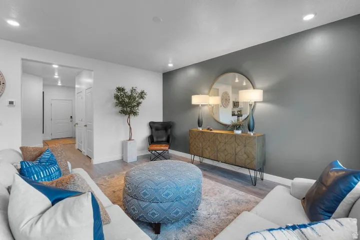 Recessed lighting, wood-finish flooring, accent wall, built-in entryway closet, and a decorative console