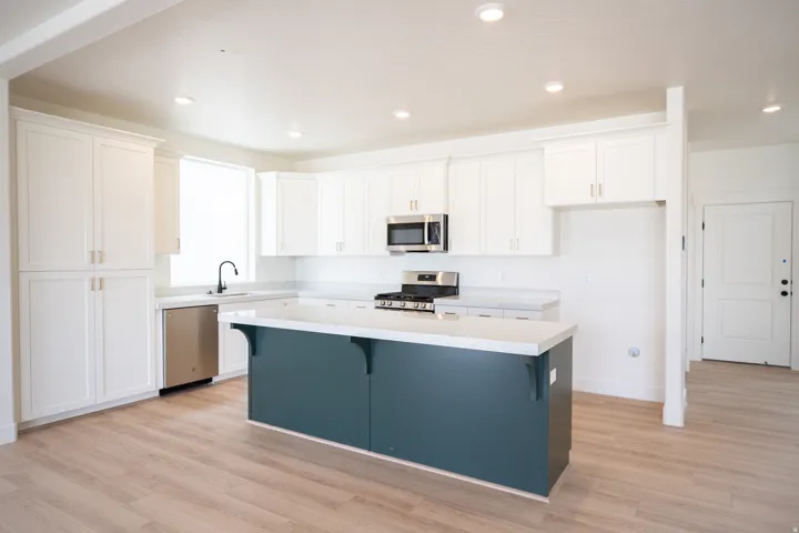 Terrific kitchen with 42" uppers, painted white wood cabinets, painted wood island, quartz slab countertops, gas range, built-in dishwasher, microwave and disposal.