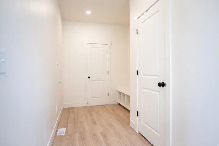 Mud room with built-in bench and cubbies adjacent to garage and powder bath.