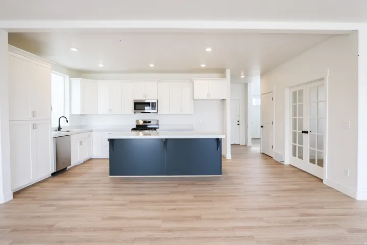 View of kitchen, den and entry from dining area.