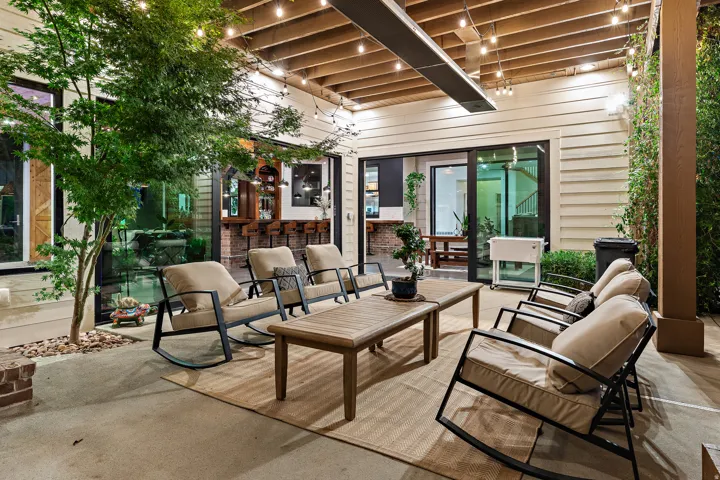 Covered patio with exposed beam ceiling, string lighting, and direct access to interior spaces through sliding glass doors