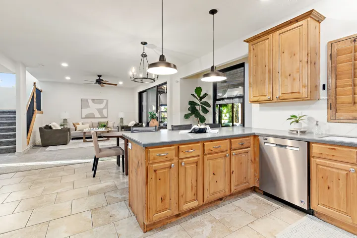 Kitchen featuring wood cabinetry, stainless steel dishwasher, and tile flooring
