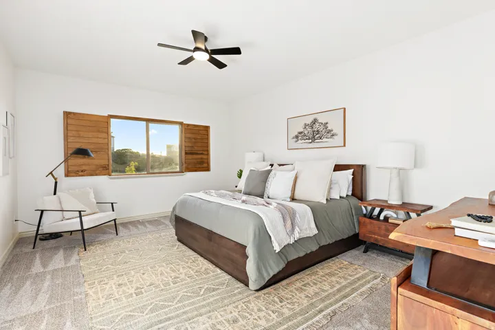 White walls with a ceiling fan, wood-finish window shutters, and carpet flooring