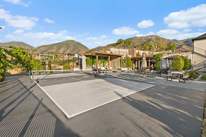 Multi-sport court, pergola-covered outdoor lounge, patio dining area, built-in outdoor seating, and mountain backdrop