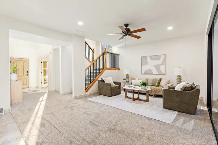 Spacious room featuring neutral carpet flooring, recessed lighting, and a ceiling fan