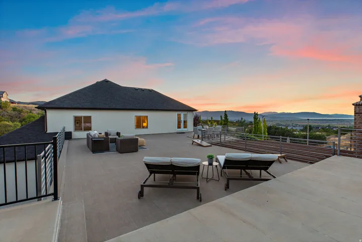 Rooftop deck featuring a metal railing, concrete surface, and distant mountain scenery