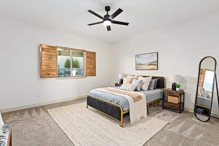 Recessed lighting, ceiling fan with integrated light, wood-finish window shutters, window with exterior landscaping, and neutral carpeting