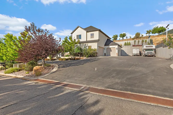 Two-story residence with a stucco and siding exterior, multi-car garage, and a spacious paved driveway