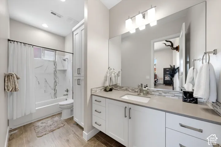 Contemporary bathroom featuring a single vanity with an undermount sink, a quartz-finish countertop, and a tiled backsplash