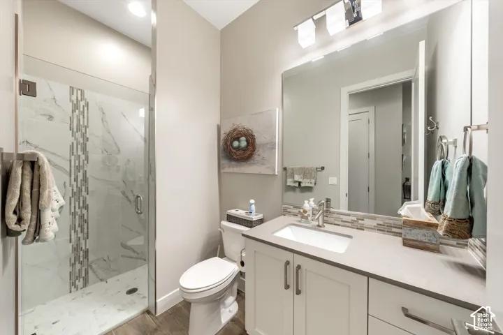 Glass-enclosed shower with a decorative tile inlay and marble-look shower surround