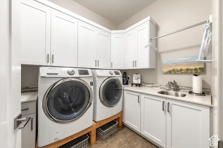 White upper and lower cabinetry, stainless steel sink, light-toned countertop, and tiled backsplash