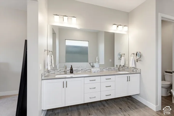 Dual vanity with white cabinetry and chrome hardware, undermount sinks, and a gray countertop