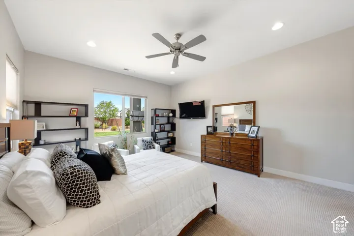 Vaulted ceiling, recessed lighting, ceiling fan, large window, and carpeted flooring