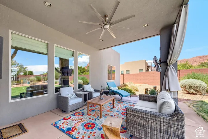 Covered patio featuring a ceiling fan, recessed lighting, and a curtained column