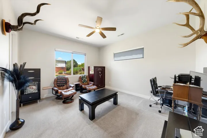 Carpeted room with a ceiling fan, a large window, and a high ceiling