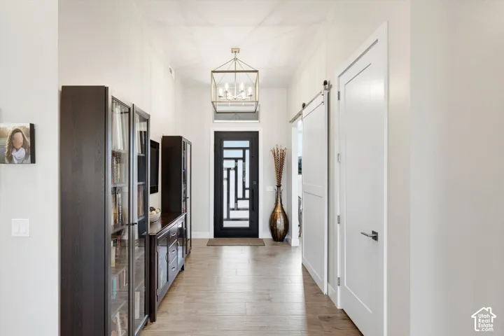 Recessed lighting illuminates the hall with wood-finish flooring