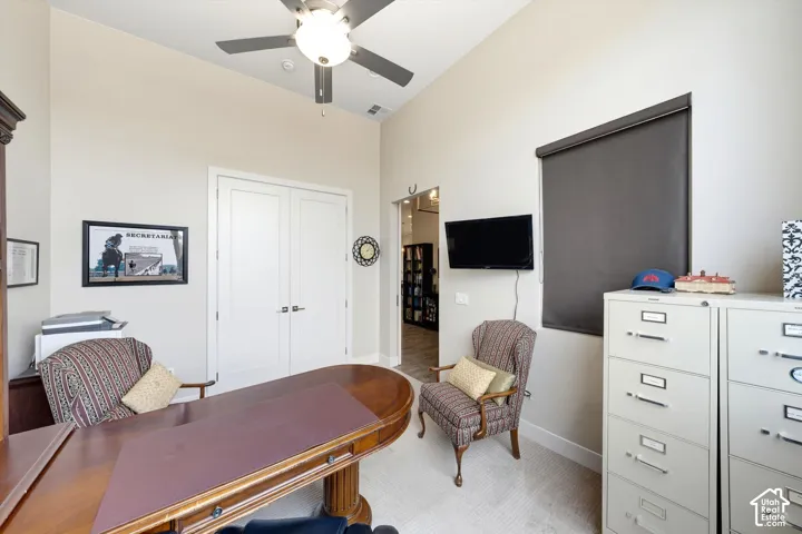 Vaulted ceiling, ceiling fan with integrated lighting, double panel doors, integrated window treatment, and light-toned carpet