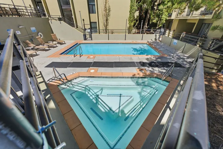 Outdoor swimming pool with an adjacent spa, both featuring blue tile accents