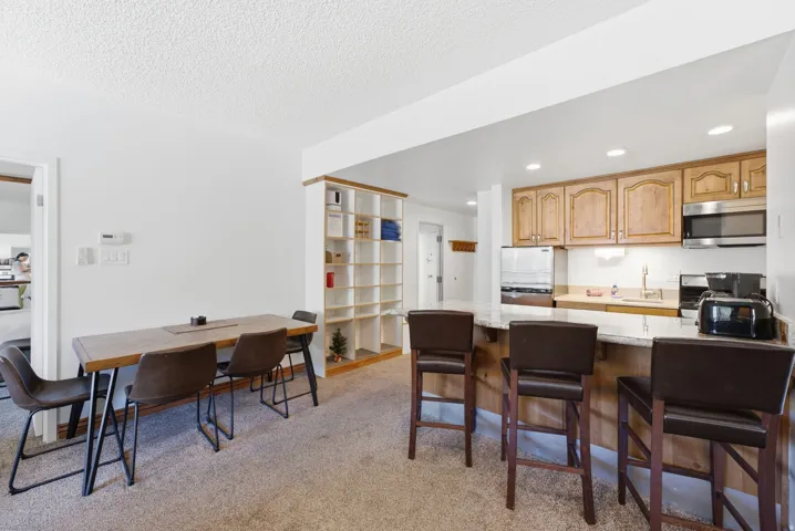 Kitchen with wood cabinetry, stainless steel appliances, and a breakfast bar