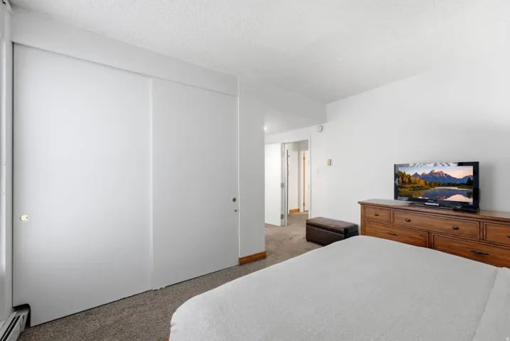 Sliding closet doors, wall-to-wall carpeting, and white painted walls