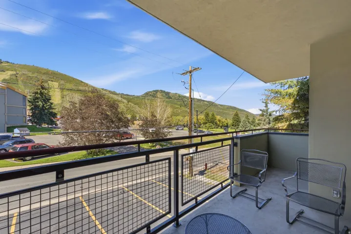 Balcony with metal railing and concrete flooring overlooking a natural landscape