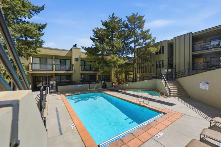Outdoor swimming pool with integrated spa and surrounding concrete decking