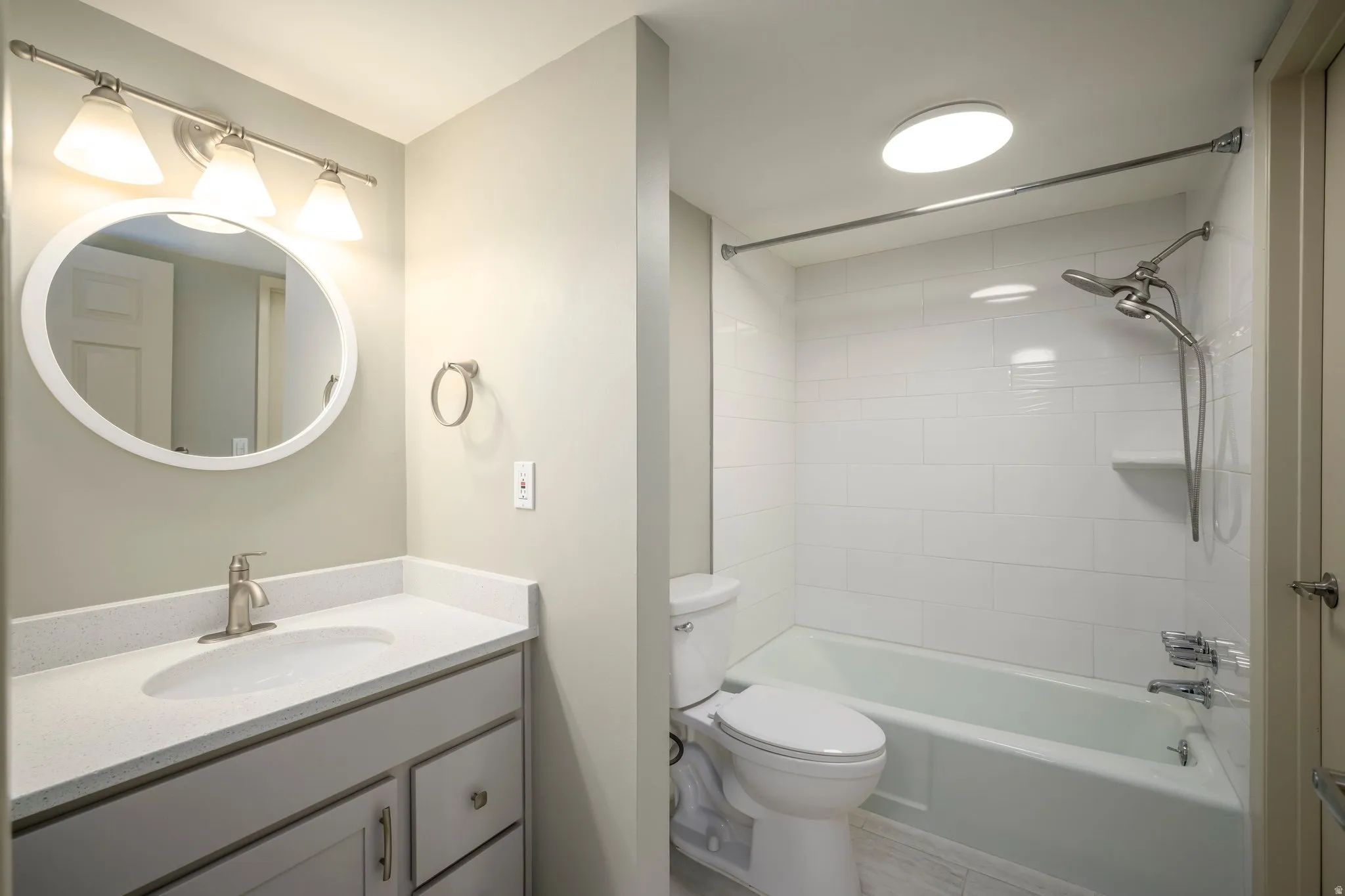 Vanity with a solid surface countertop, undermount sink, and brushed nickel faucet