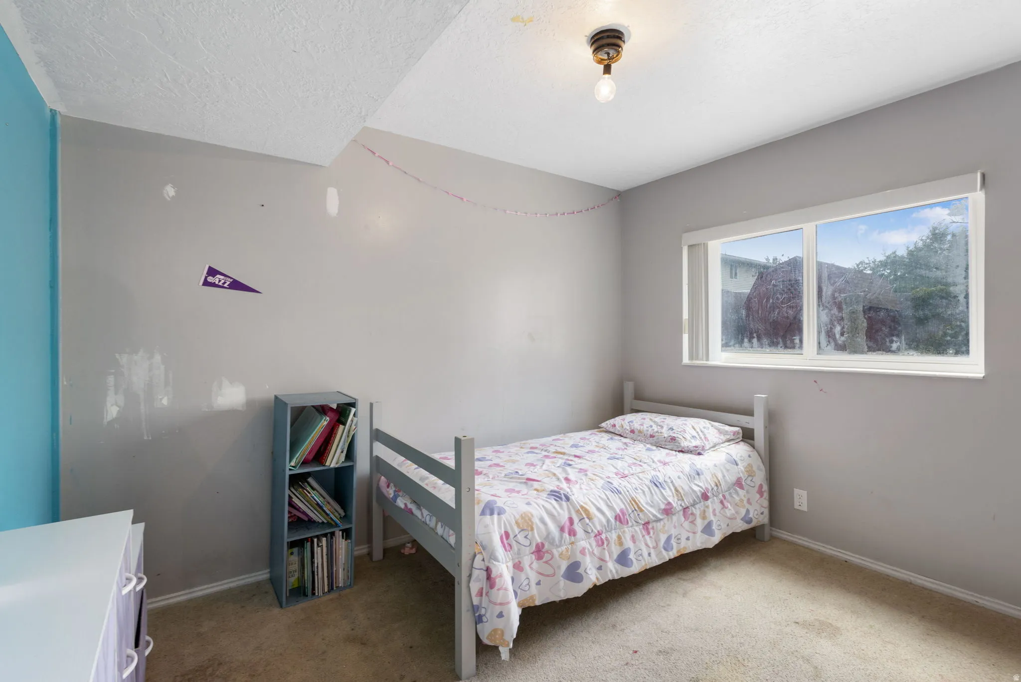 Carpeted flooring with painted walls and a window with exterior views